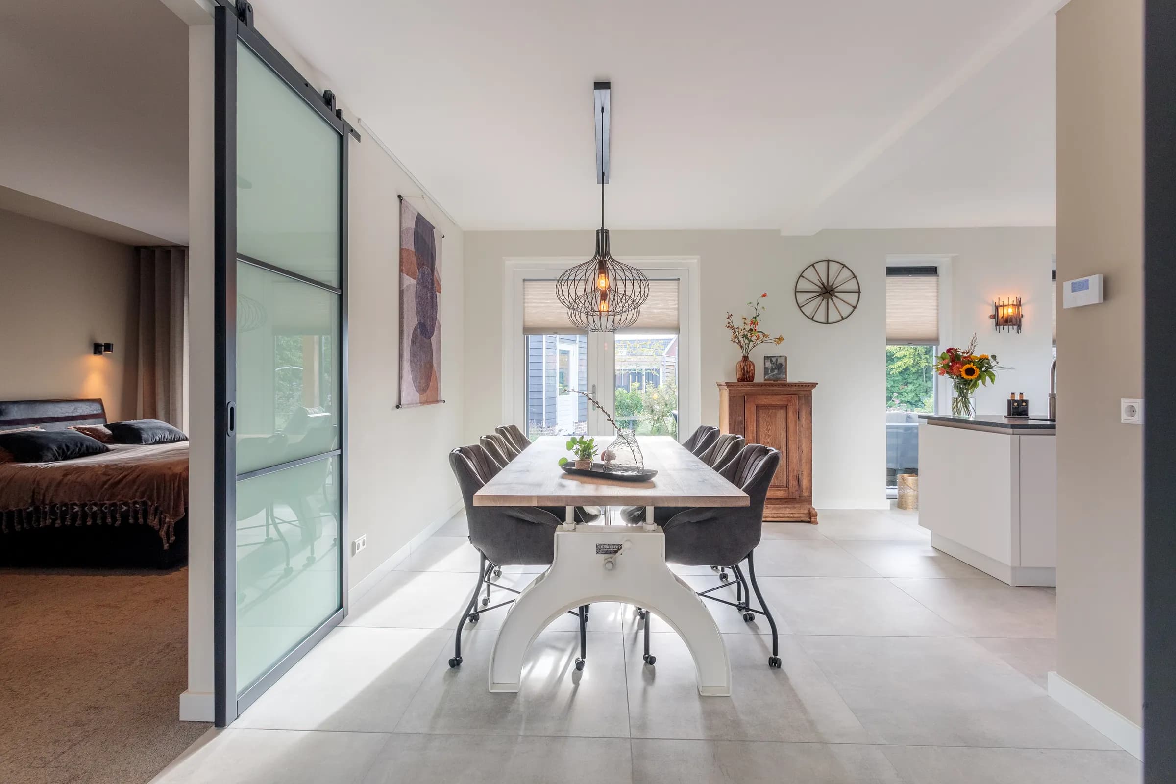 Oak dining table on a white steel column base with a pendant lamp in the Loosman family home