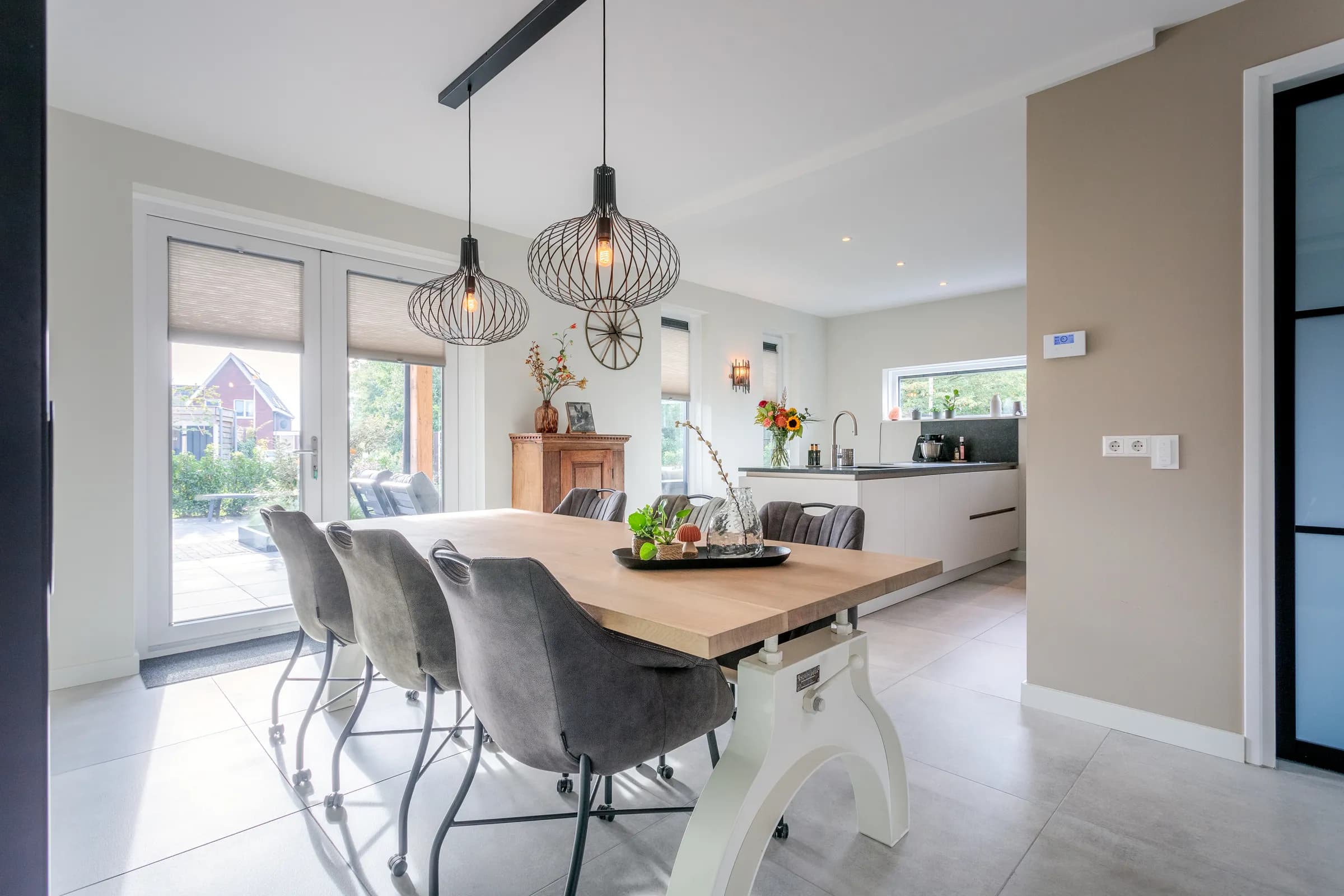 Full view of the oak dining table with chairs on a white steel column base in the Loosman family home