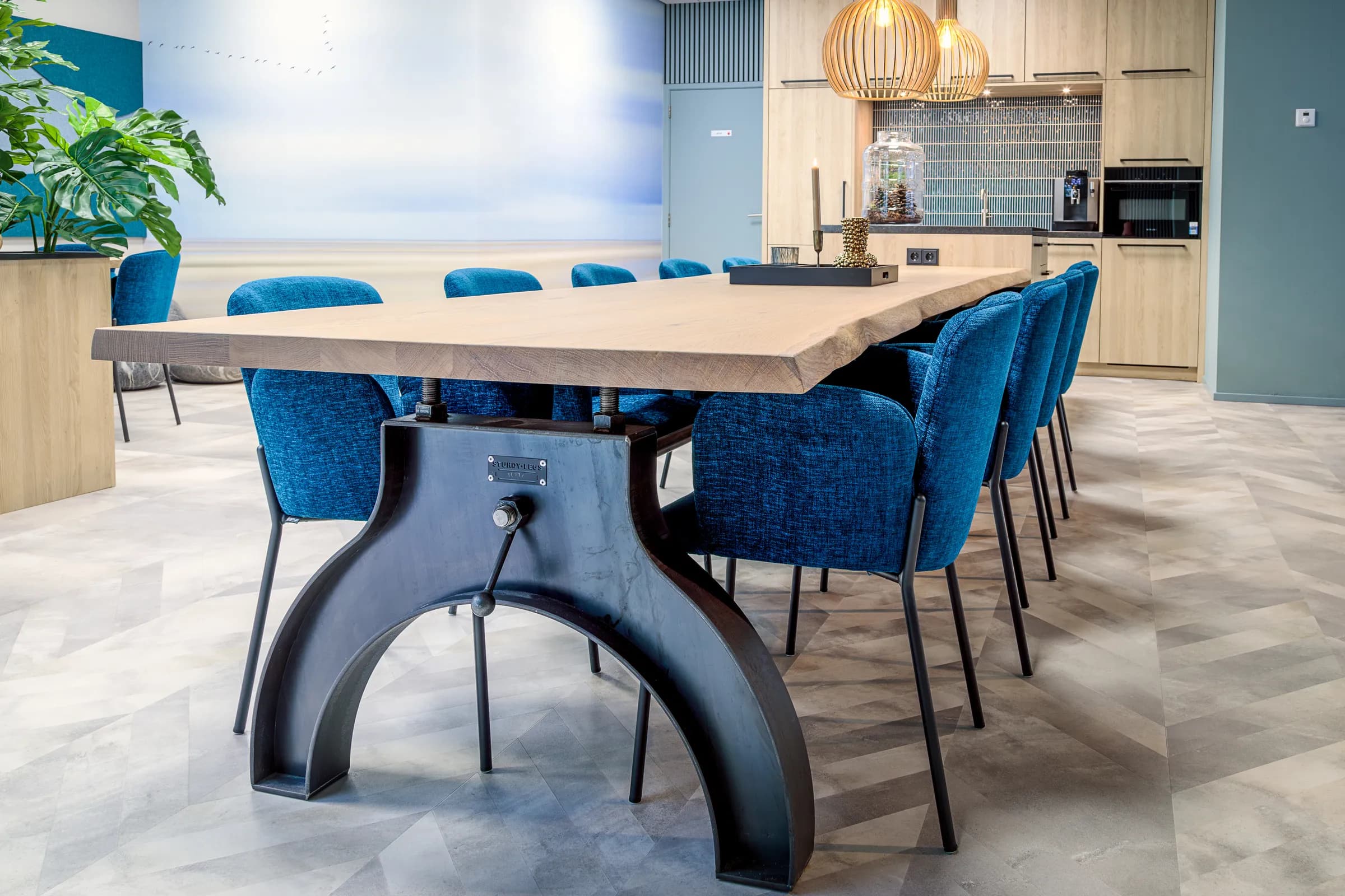 Light oak table and black cast iron column base up close in the Wiz Arts office