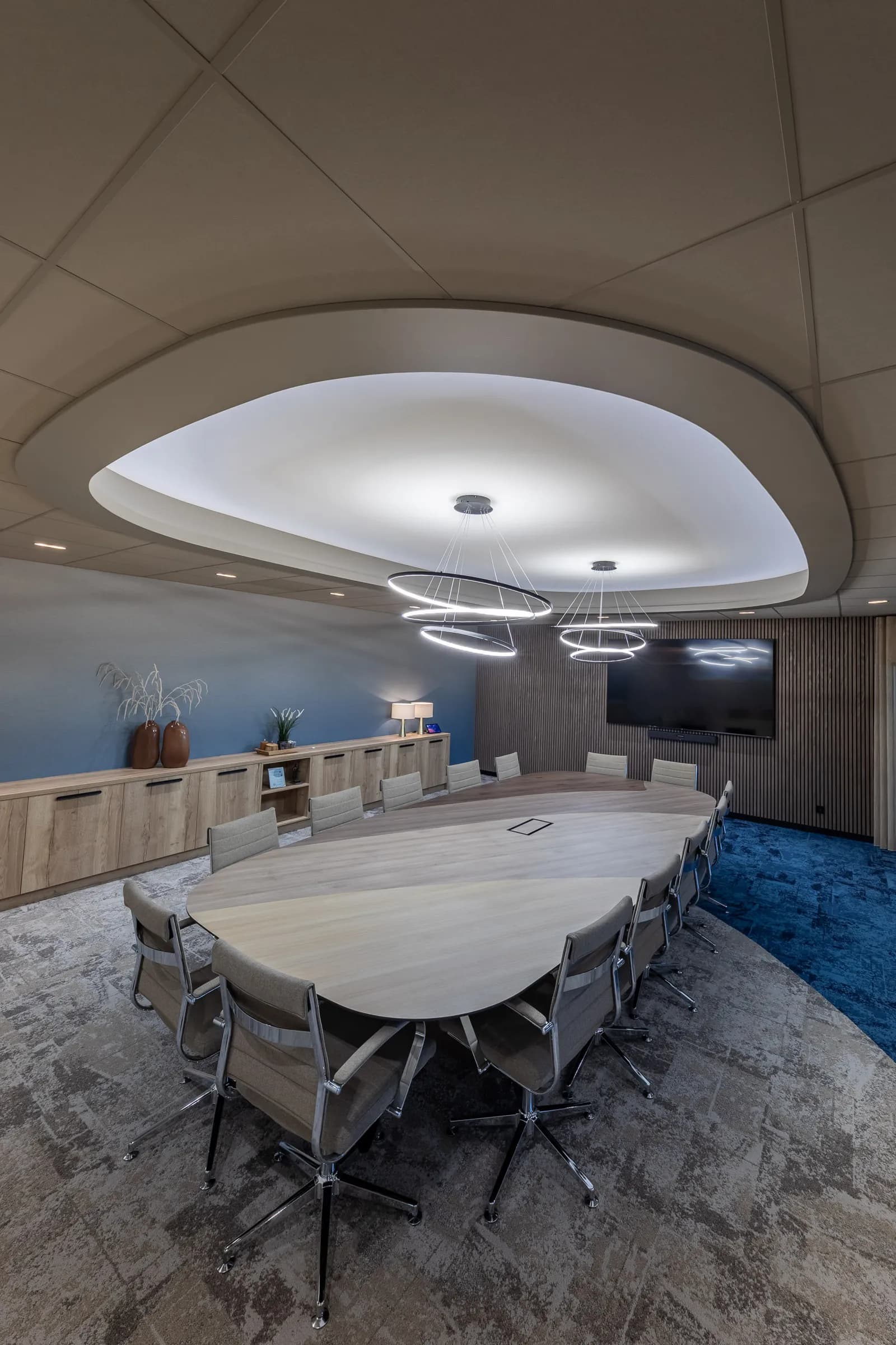 Boardroom at Kramer Seafood with an oval table, a wall screen and a curved ceiling with a ring light